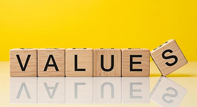 Wooden blocks spelling VALUES on a reflective surface against a vibrant yellow backdrop symbolizing core principles and ethical standards in a bright optimistic environment promoting trust and integri photo