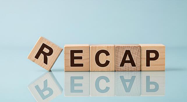 Wooden blocks spelling RECAP on a reflective surface against a light blue background symbolizing a summary review or overview of past events with a focus on business and project management photo