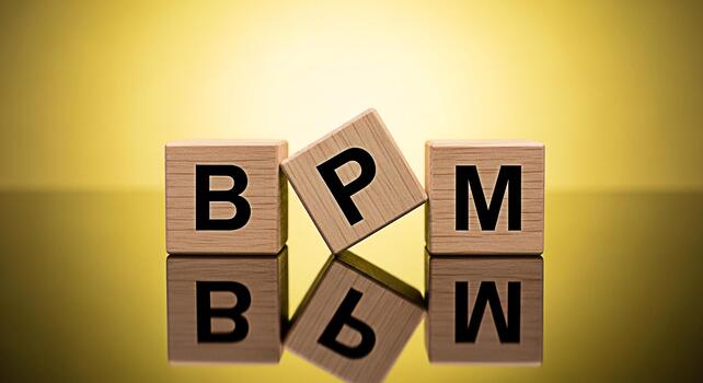 Wooden blocks displaying BPM on a reflective surface against a golden backdrop symbolizing business process management and optimization for efficiency and strategic planning in a corporate environment photo