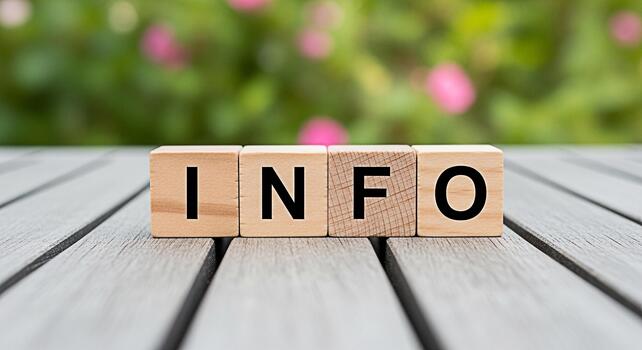 Wooden blocks spelling INFO resting on a gray wooden surface in a garden setting conveying a message of information knowledge and helpful resources in a natural and accessible way photo