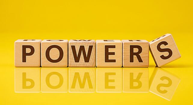 Wooden blocks spelling POWERS on a reflective yellow surface symbolizing strength influence and the potential for success in business and personal development conveying a message of empowerment and ca photo