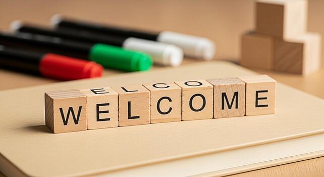 Wooden blocks spelling Welcome resting on a notebook in a bright inviting office environment symbolizing hospitality new beginnings and a friendly inclusive atmosphere for visitors and team members photo