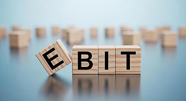 Wooden blocks spelling EBIT on a reflective surface symbolizing earnings before interest and taxes in a financial setting representing profitability and business performance with a focus on accounting photo