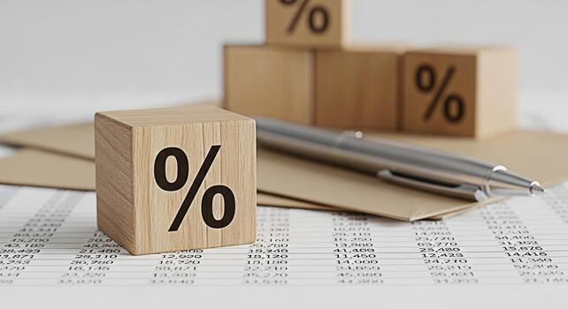 Wooden blocks displaying percentage signs resting on financial document with a pen symbolizing interest rates and investment analysis in a neutraltoned professional setting creating a mood of financia photo
