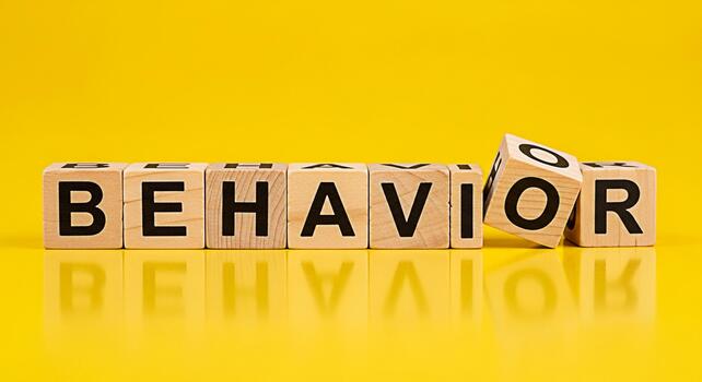 Wooden blocks spelling Behavior on a bright yellow background reflecting the concept of understanding and influencing behavior in various contexts like psychology education and social dynamics photo