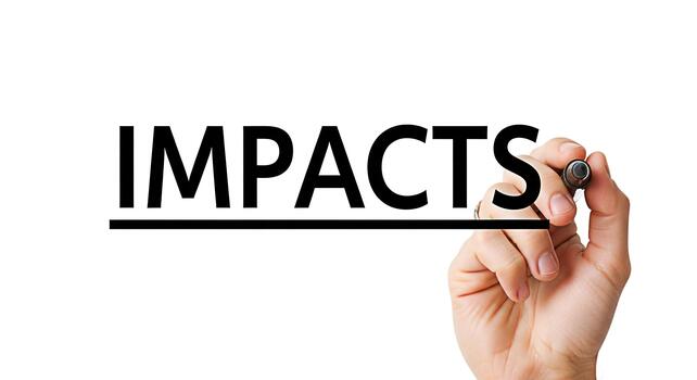 Hand underlining the word Impacts on a whiteboard with a black marker emphasizing the significance of consequences and effects in a business or educational setting conveying a message of importance photo