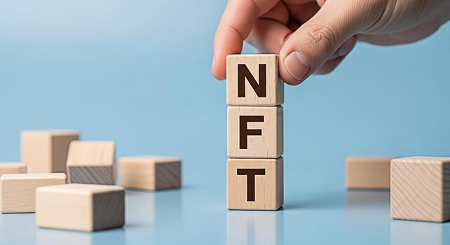 Hand placing wooden blocks spelling NFT on a blue surface symbolizing the creation and investment in nonfungible tokens representing digital assets and blockchain technology creating a modern and inno photo