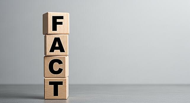 Wooden blocks spelling FACT stacked on a gray surface against a neutral background representing truth information and knowledge conveying a sense of accuracy and reliability in a clean and minimalist photo
