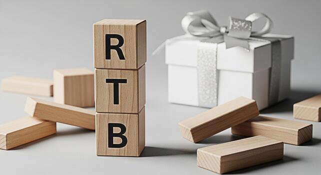 Wooden blocks spelling RTB are stacked next to a gift box with a silver ribbon on a gray surface symbolizing a return to business and a positive outlook for future success and growth photo
