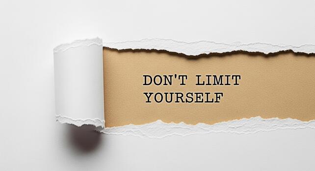 Inspirational message Dont Limit Yourself revealed through torn white paper creating a powerful visual metaphor for breaking barriers and achieving potential fostering a sense of motivation and possib photo