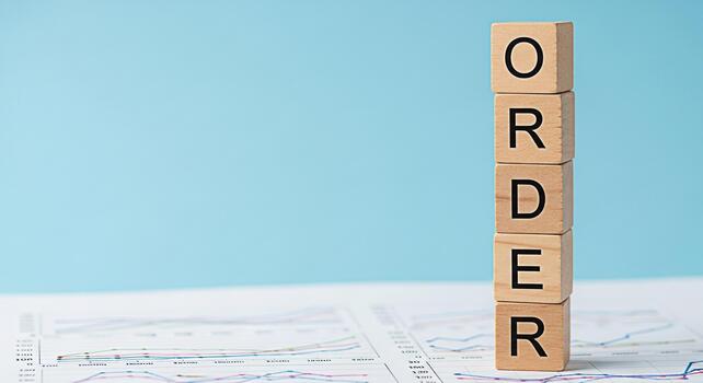 Wooden blocks spelling ORDER stacked on a financial chart in a bright studio setting representing business planning success and the importance of organization for achieving goals and maintaining contr photo