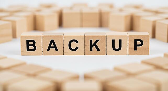 Wooden blocks spelling BACKUP on a white surface surrounded by other blocks representing data protection and security in a digital environment emphasizing the importance of safeguarding information photo