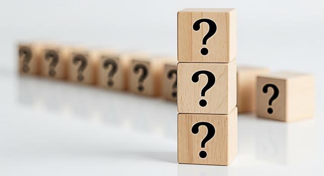 Stacked wooden blocks displaying question marks on a white surface representing uncertainty and the need for answers in a clean minimalist environment evoking curiosity and problemsolving photo