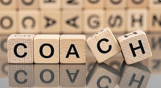 Wooden blocks spelling COACH on a reflective surface symbolizing guidance and mentorship in a business environment conveying a message of support and professional development photo