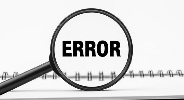 Magnifying glass revealing the word ERROR on a notepad symbolizing a problem found during investigation highlighting the concept of debugging troubleshooting and quality assurance in a minimalist sett photo