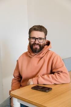 Man smiling at camera in casual hoodie. Representation of friendliness, trust, openness and approachable character during relaxed communication at home or workplace. photo