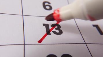 highlighting datum siffra 13 på en kalender, med en djärv röd korsa mark betona ett Viktig påminnelse eller planerad händelse. video