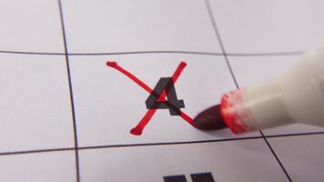 Highlighting date number 4 on a calendar, with a bold red cross mark emphasizing an important reminder or scheduled event. video