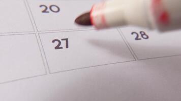 Marking the date number 27, focusing on the number highlighted with a red cross on the calendar. Represents deadlines, reminders, planning, and time management video
