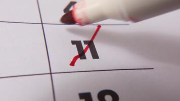 highlighting datum siffra 11 på en kalender, med en djärv röd korsa mark betona ett Viktig påminnelse eller planerad händelse. video