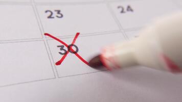marcatura il Data numero 30, messa a fuoco su il numero evidenziato con un' rosso attraversare su il calendario. rappresenta scadenze, promemoria, pianificazione, e tempo gestione video