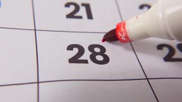 highlighting datum siffra 28 på en kalender, med en djärv röd korsa mark betona ett Viktig påminnelse eller planerad händelse. video
