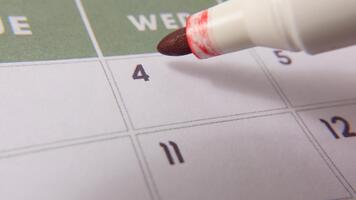 märkning de datum siffra 4, fokusera på de siffra markerad med en röd korsa på de kalender. representerar deadlines, påminnelser, planera, och tid förvaltning video