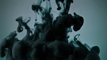 Abstract dark ink cloud diffusion in water, creating mesmerizing smoky patterns with a subtle gradient background video