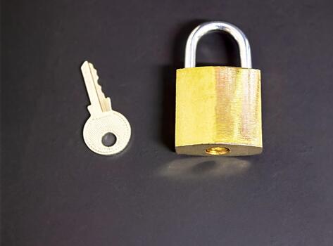 A bronze-colored lock and a key next to it on a black background, a security concept, as well as a concept of cybersecurity and data protection, with empty space for text photo
