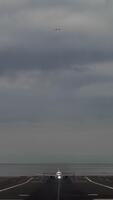 vertical - uma passageiro avião picaretas acima velocidade, acelerando em uma pista este começa às a da água Beira e leva fora enquanto a de outros avião dentro a fundo é se aproximando para aterrissagem video