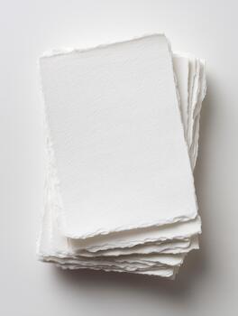 Stack of premium handmade deckle edge white paper sheets, perfect for invitations, stationery, or artistic projects photo