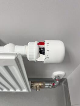 Radiator heating system installation with a thermostat valve, showcasing a cold season setup, emphasizing engineering and efficiency in home heating solutions photo