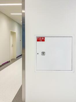 Access panel for utilities, featuring a white hatch on a wall, located in a modern corridor, demonstrating functionality and design in a commercial building environment photo