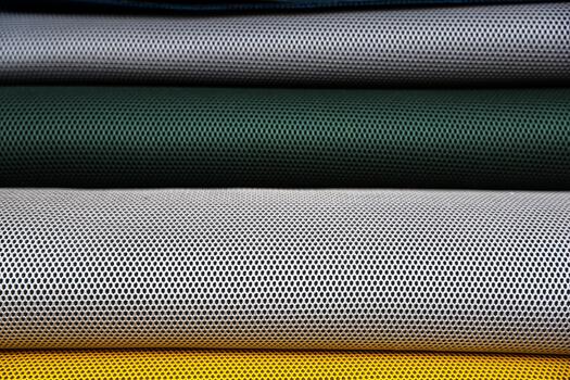 Stacked perforated mesh rolls in various colors photo