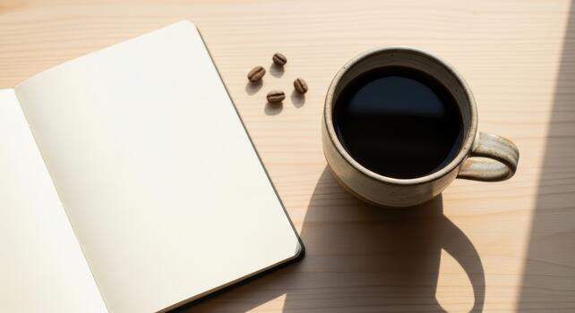 A notebook with blank pages next to a cup of dark coffee and coffee beans on a wooden surface photo