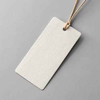 Elegant rectangular paper tag mockup on pale gray background with realistic paper texture and subtle studio lighting for professional branding photo