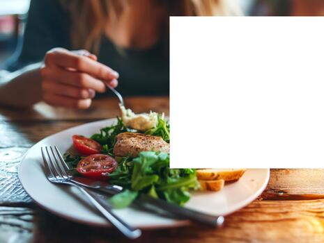 A hand holds a fork, delicately taking a bite of a fresh, healthy meal on a rustic wooden table, illustrating the practice of mindful eating photo
