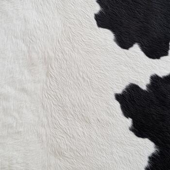 Detailed close-up reveals the intricate pattern and texture of cow hide with distinct black and white areas, highlighting natural beauty photo