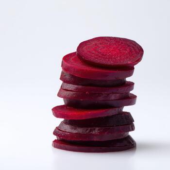 A stack of vibrant red beet slices, neatly arranged and isolated on a clean white background, showcasing their texture and color photo