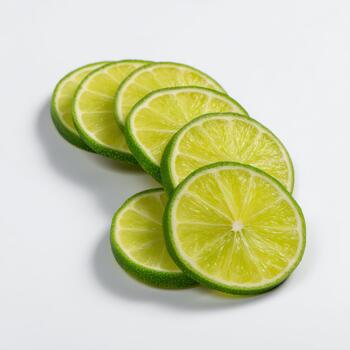 Several thin slices of fresh lime arranged in a cascading pattern, isolated on white background photo