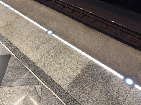 Lighted line in the subway to prevent accidents. Stand behind the line when a train arrives to ensure safety. Warning line at the edge of the platform is illuminated for visibility photo