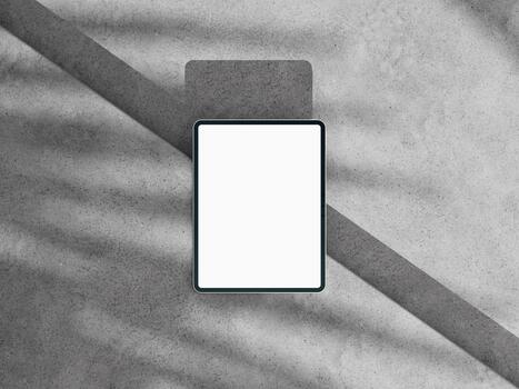 Top view tablet mockup on concrete, bold diagonal shadow, clean screen for web or app. photo