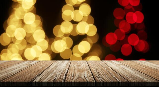 Rustic wooden table surface with warm golden and red bokeh lights creating a festive, celebratory atmosphere for holiday promotions photo