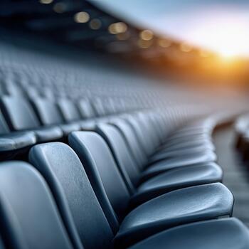 Empty graffiti layered plastic seats in an open stadium during sunset photo