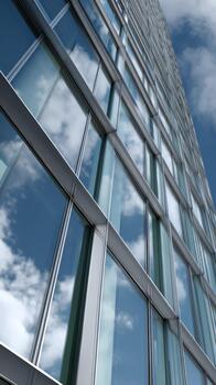 moderno vaso edificio reflejando azul cielo y nubes desde un bajo ángulo foto