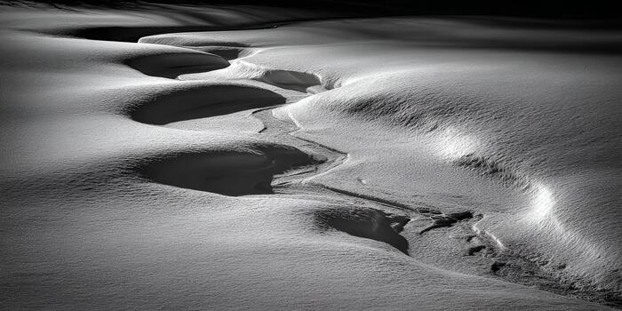 Abstract patterns of light and shadow define the pristine texture of a snow covered winter landscape photo