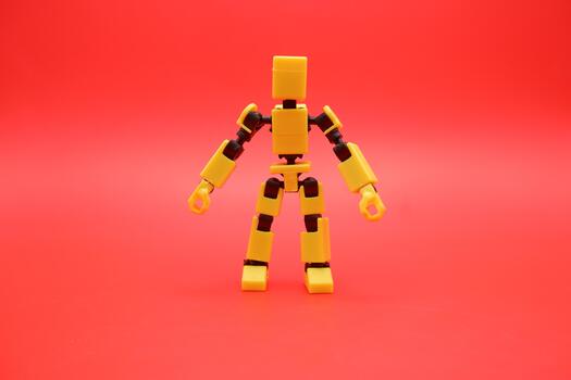 Yellow Poseable Action Figure on Red Background photo