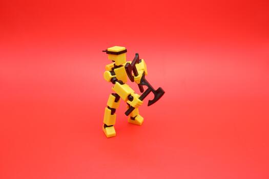Articulated Yellow Robot Toy in Combat Pose with Axes photo