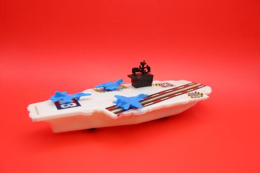 Mini Warship Toy with Blue Jet Planes Displayed on Red Surface photo