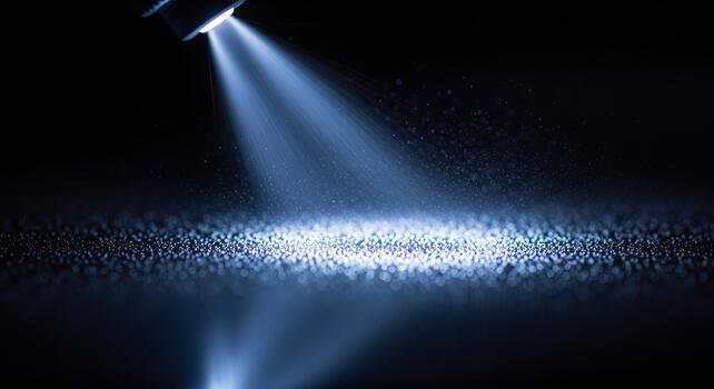 A beam of light illuminating a surface covered with small particles in a dark environment photo